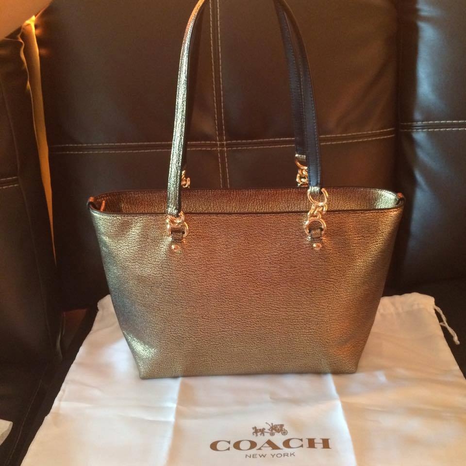 "Coach รหัส F37117 Metallic Small Sophie Tote สี Gold ขนาด 13 1/2"" (L) x 8 1/4"" (H) x 4 1/4"" (W) ไม่มีตำหนิค่ะของใหม่ป้ายห้อย รายละเอียดเพิ่มเติม สีทอง สวยหรูมากๆ สินค้างานช็อปมีถุงผ้าให้ อุปกรณ์อยู่ครบยังไม่ได้ใช้ป้ายห้อยยังอยู่ ทรงสวยค่ะ ใบใหญ่จุของได้เยอะ ขอรูปเพิ่มเติมได้ทุกมุมค่ะ"