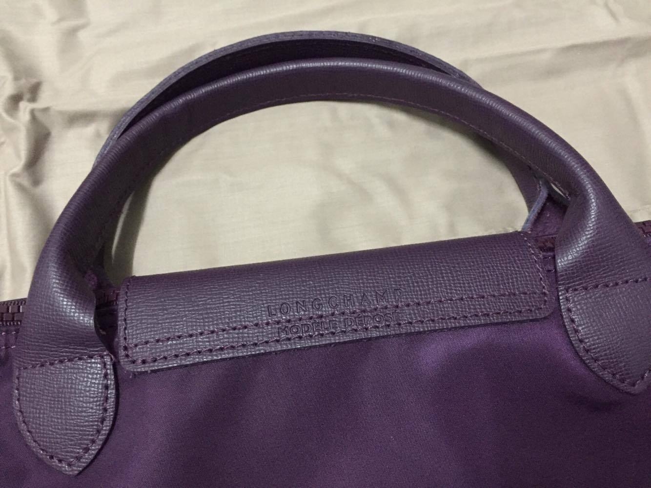 กระเป๋า Longchamp Le Pliage Neo ราคา : 4200 บาท ยี่ห้อ: Longchamp รหัสสินค้า : Le Pliage Neo สี Bilberry ขนาด : 40x31x18 cm Size L รายละเอียดเพิ่มเติม : กระเป๋าแบรนด์ Longchamp รุ่น Neo ไซส์ L สีม่วงเปลือกมังคุด หูสั้น เป็นสินค้าใหม่ไม่เคยผ่านการใช้งาน